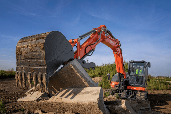 Kubota KX080 excavator picking up slabs of concrete